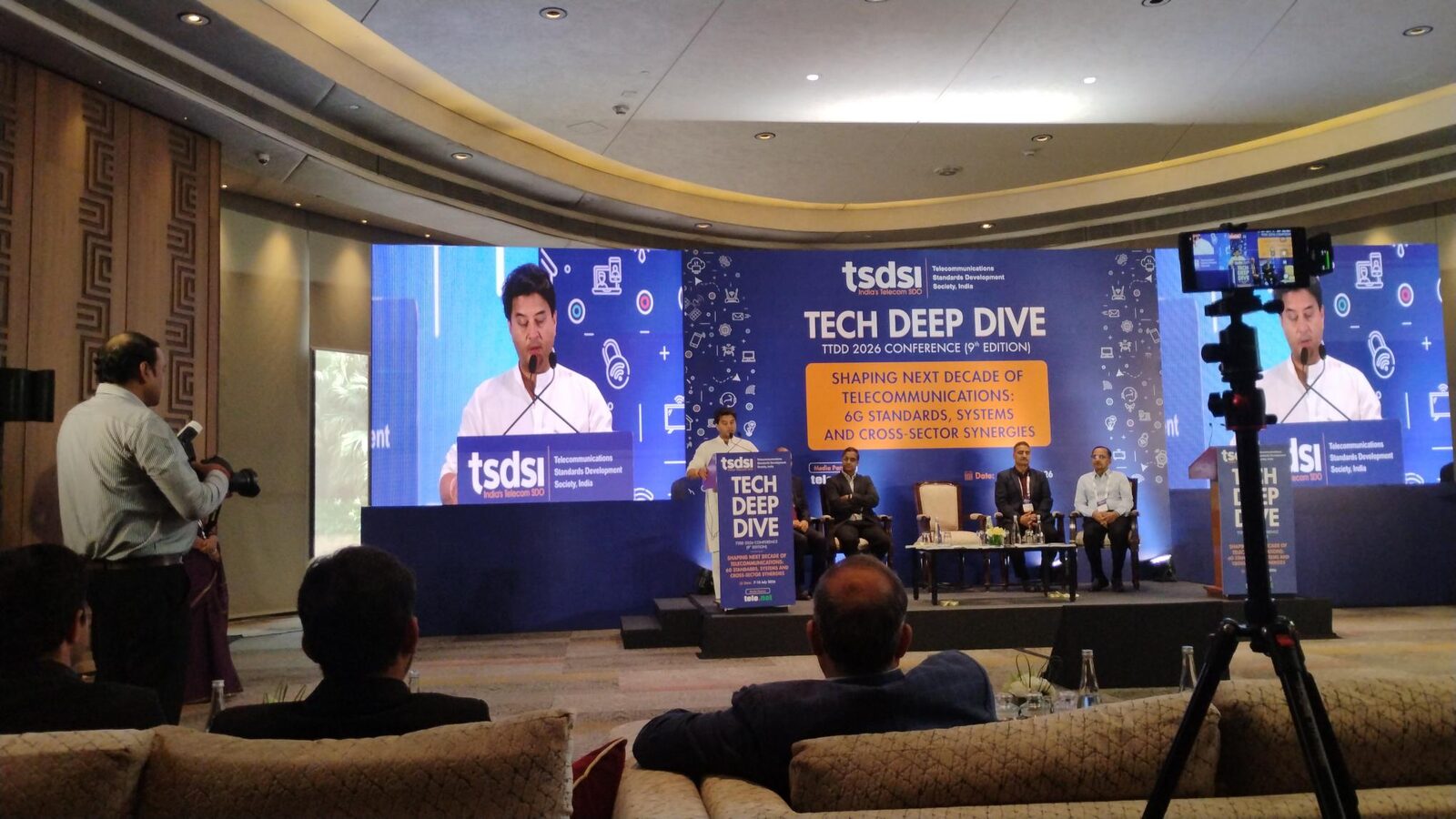 A technical session in progress at TSDSI Tech Deep Dive 2026, with presentation screens and event cameras covering the stage.